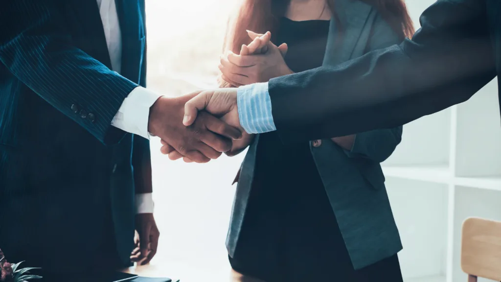 Closeup of handshake between subscription business owner and failed payment recovery company